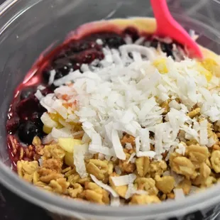 Protein yogurt with fresh fruit, granola and shredded coconut.