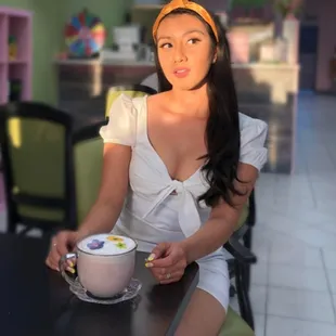  a woman sitting at a table with a cup of coffee