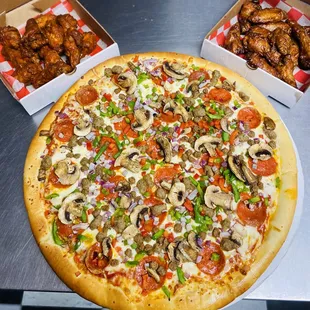a pizza with mushrooms, peppers, peppers, and chicken wings
