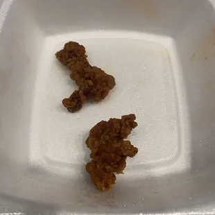 two pieces of food left in a styrofoam container