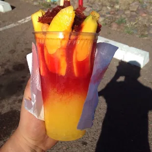 a hand holding a drink with a straw