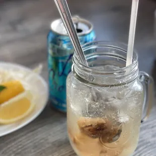 a glass of iced tea and a plate of lemon slices