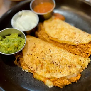 two quesadillas on a plate with guacamole