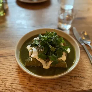 a bowl of soup on a wooden table