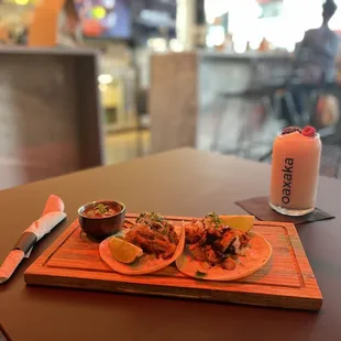 two tacos and a drink on a table