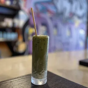 a green drink with a straw in a glass