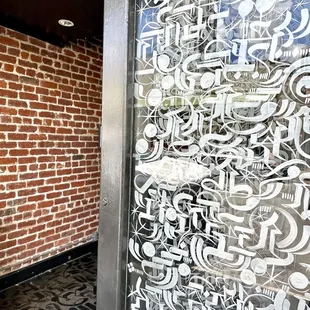 The glass windows, floors, and ceiling all have the same motif by artist, Tonk.