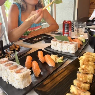 a woman eating sushi with chopsticks