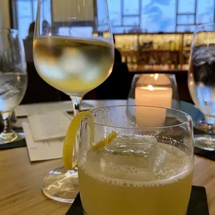 a glass of white wine and a candle