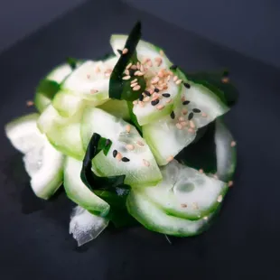 a plate of cucumbers with sesame seeds