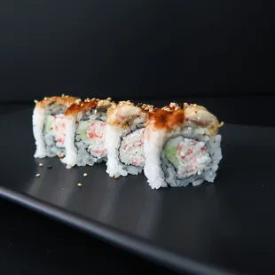 a sushi roll on a black plate