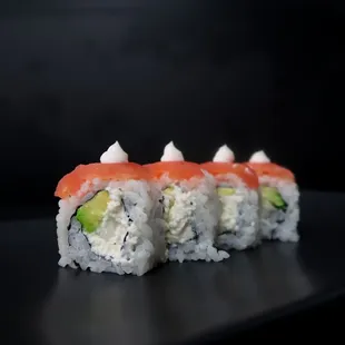 a sushi roll with salmon and avocado