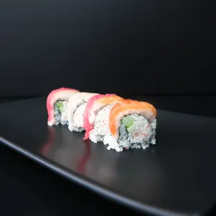 a sushi roll on a black plate