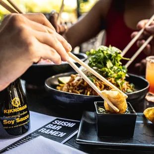 chopsticks being held over a plate of food