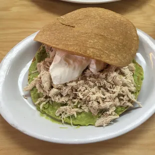 Tostadas a la siberia.2 large corn tortillas fried topped with Guac, shredded chicken and sour cream.
