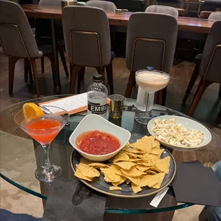 a glass table with chips and drinks