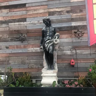 a statue in front of a wooden wall