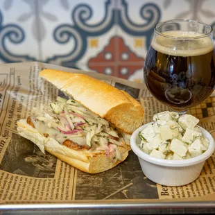 a sandwich with coleslaw and a glass of beer