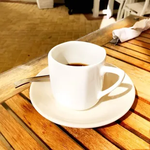 a cup of coffee on a wooden table