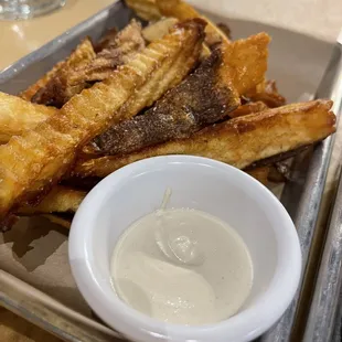 a tray of fries and a bowl of dip