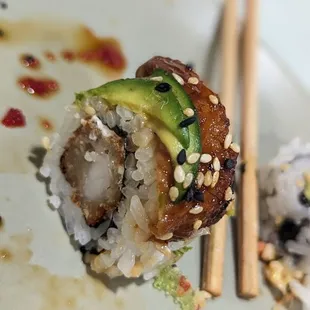 a close up of a sushi with chopsticks