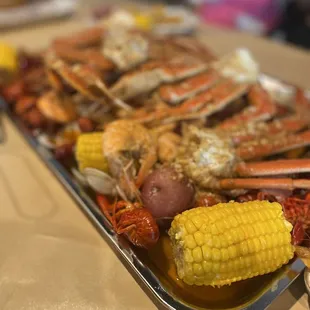 crab legs, corn, potatoes, corn on the cob
