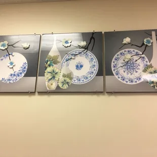 three blue and white plates hanging on a wall