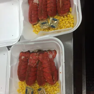two trays of lobster and corn
