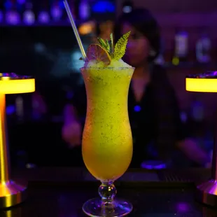 a drink with a straw and a garnish garnish