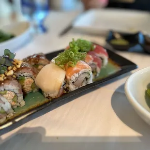 a plate of sushi and a bowl of green beans
