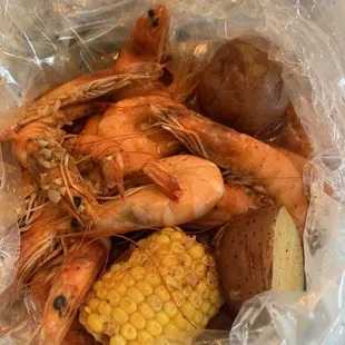 shrimp, potatoes, corn and potatoes in a plastic bag