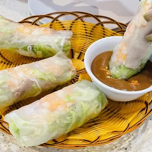 a bowl of dipping sauce and rolls
