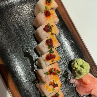 a plate of sushi with salmon and avocado