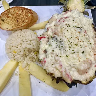Pineapple stuffed with shrimp, crab, steak and cheese.