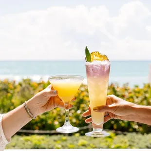 two people toasting with cocktails