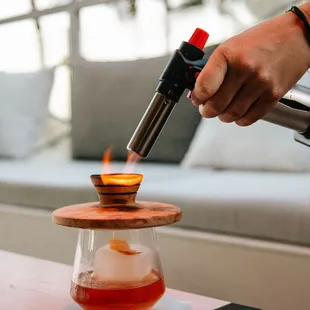 a person using a blow torch to make a drink