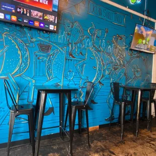 tables and chairs in front of a blue wall