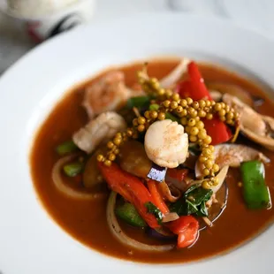 a bowl of soup with shrimp and vegetables