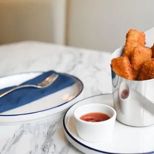 a plate of deep fried chicken nuggies and dipping sauce