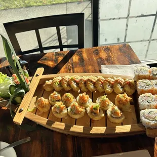 a variety of sushi on a wooden platter