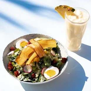 a bowl of salad and a drink