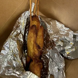 a chicken skewer wrapped in tin foil