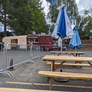 a table with an umbrella and a firetruck in the background