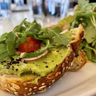 Avocado toast ($14, Dec&apos;21) seeded Noble bread, tomato, radish