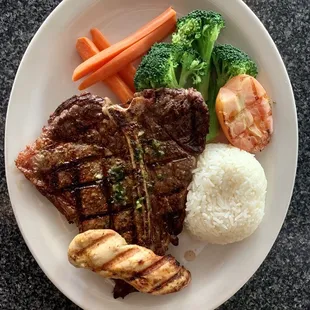 a plate of meat, rice, and vegetables
