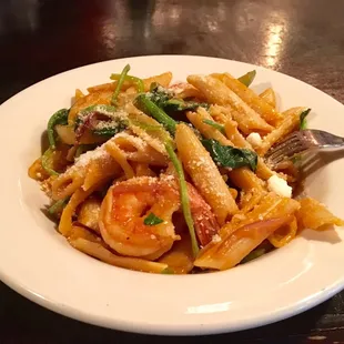 a plate of pasta with shrimp and asparagus