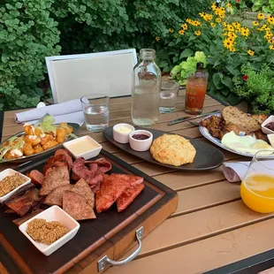 Some bomb ass biscuit with jam and duck fat butter, cheese curds, and duck meats on a board