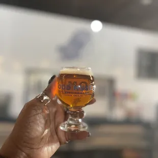 a person holding a glass of beer