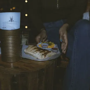 a person sitting at a table with a plate of food
