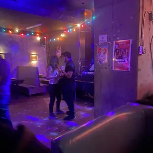 two people dancing in a dimly lit room